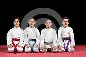 Children in kimono sitting on tatami on martial arts seminar. Selective focus