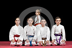 Children in kimono sitting on tatami on martial arts seminar. Selective focus