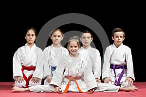 Children in kimono sitting on tatami on martial arts seminar. Selective focus