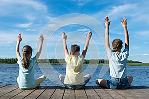 Children on the lake doing yoga in good weather