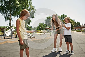 Children laugh from offended boy with old phone