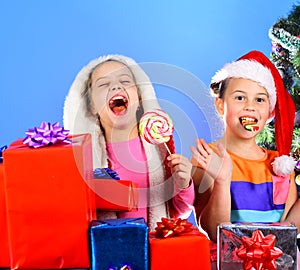 Children with laughing faces eat candies on light blue background.