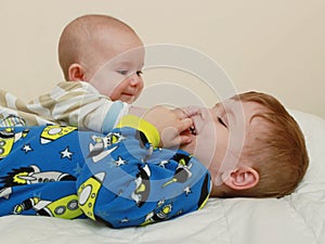 Children laughing and playing in bed