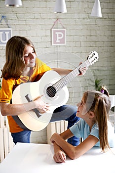 Children learn to play guitar