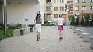 Children learn to ride scooter on sunny summer day. Kids play outdoors with scooters. Active leisure and outdoor sport