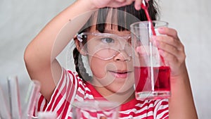 Children are learning and doing science experiments in the classroom. Little girl playing science experiment for home schooling. E