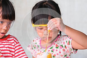 Children are learning and doing science experiments in the classroom. Two little sisters playing science experiment for home