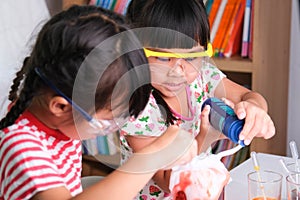 Children are learning and doing science experiments in the classroom. Two little sisters playing science experiment for home