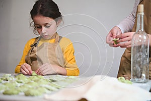 Children learning making dumplings during a cooking class. Preparing homemade varennyky according to traditional