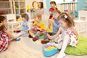 Children learning musical instruments on lesson in kindergarten