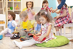 Children learning musical instruments on lesson in kindergarten