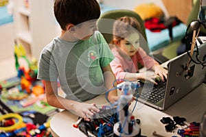 Children learning repairing getting lesson control robot arm, robotic machine arm in home workshop, technology future science