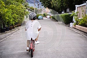 Children learning to drive a bicycle on a driveway outside
