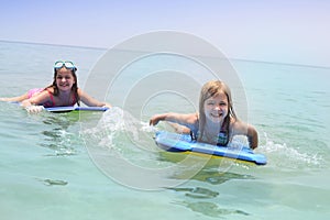 Children learning to swim and surf with body board