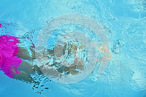 Children leg in blue water pool.