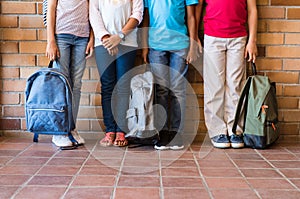 Children legs with backpacks at school