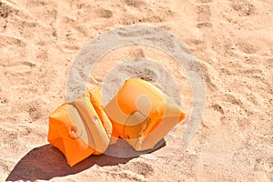 Children life jacket for swimming lie on the sand on the beach