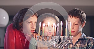 Children lighting Hanukka candles at home