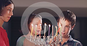 Children lighting Hanukka candles at home