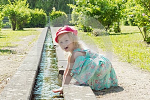 Children. Little girl playing with water in a creek on a hot sunny day