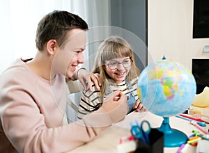 Children look at the globe, study geography and dream of traveling. Home education, distance learning, children`s emotions