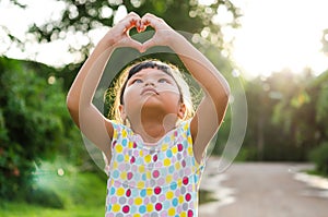 Children look pass hand heart