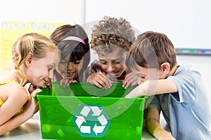 Children looking at plastic bottles in recycling box