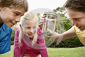 Children Looking At Snake In Jar