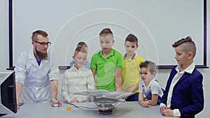 Children looks at dancing sand on Chladni plate