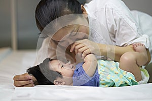 Children lying on a bed with his mother to take care of love and warmth.