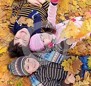 Children lying in fall leaves