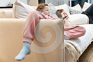 Children lying on the sofa and watching TV interesting cartoon