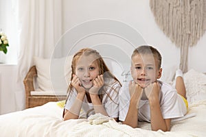 Children lying on their bellies in a bedroom