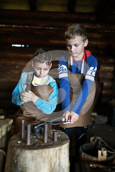 Children make coin in forge
