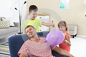 Children making balloon explosion joke for their father