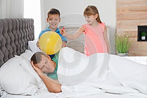 Children making balloon explosion joke for their father