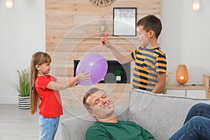 Children making balloon explosion joke for their father