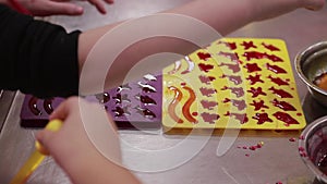 children making jelly candies. Close up of filling molds for curing