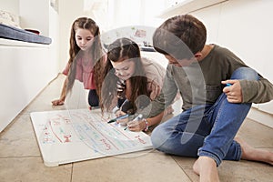 Children Making List Of Chores On Whiteboard At Home