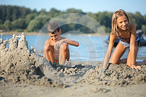 Children making sand castle at tropical beach