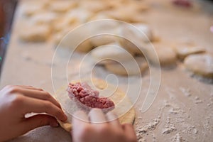 Children making traditional Russian pirozhky pastries with meat