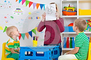 Children with mom and draw pictures in the kids room.