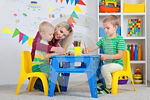 Children with mom and draw pictures in the kids room