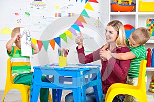 Children with mom draw pictures in the kids room.Have fun together.