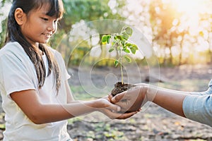 children and mom helping planting young tree. eco concept