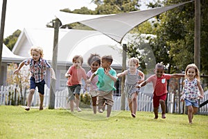 Children At Montessori School Having Fun Outdoors During Break