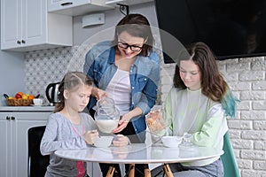 Children with mother eating at home in kitchen