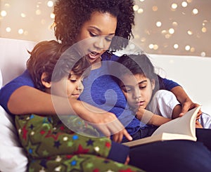 Children, mother and reading a book in a family home for story time on lounge sofa with bokeh. A woman or mom with kids