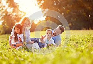 Children in nature make soap bubbles