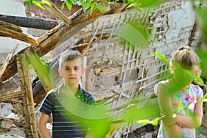 Children are near the ruined house, the concept of natural disaster, fire, and devastation.